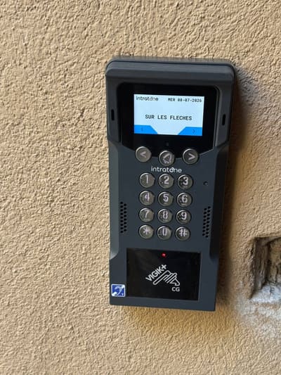 Platine de rue d'interphone posée sur une façade en enduit clair