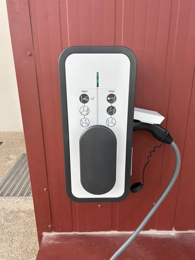 Borne de recharge pour voiture électrique installée sur un mur extérieur